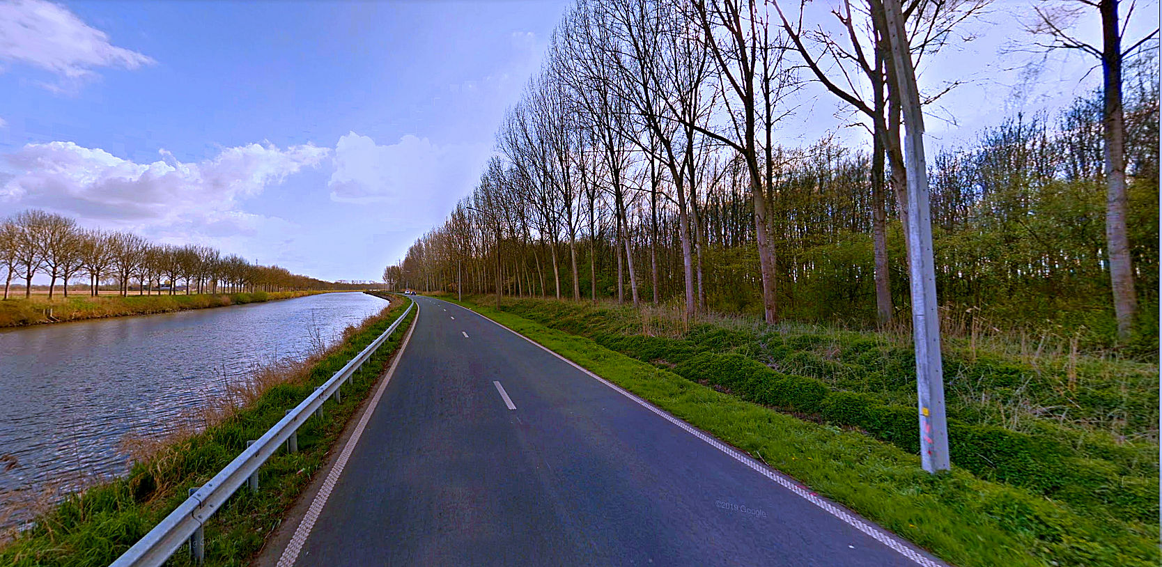 Straße mit kanalähnlichem Flußlauf bei Deinze